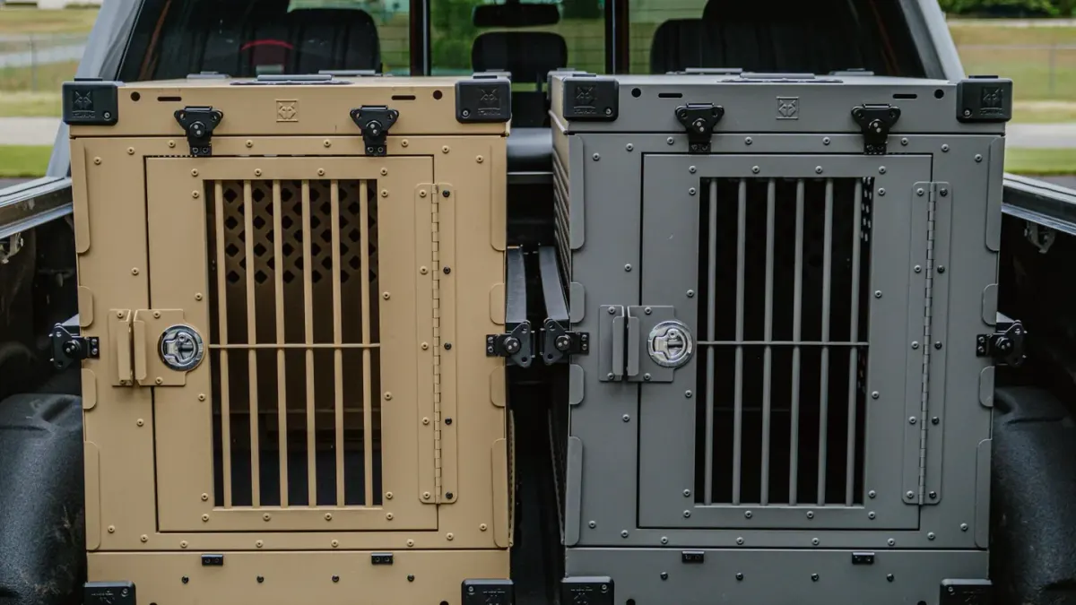A hard-sided dog crate strapped into the cargo area of an SUV