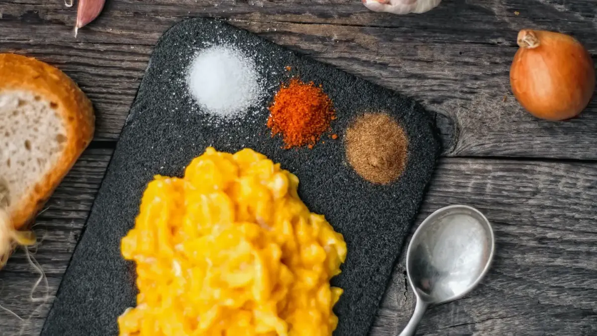 A plain scrambled egg served next to a bowl of dog food