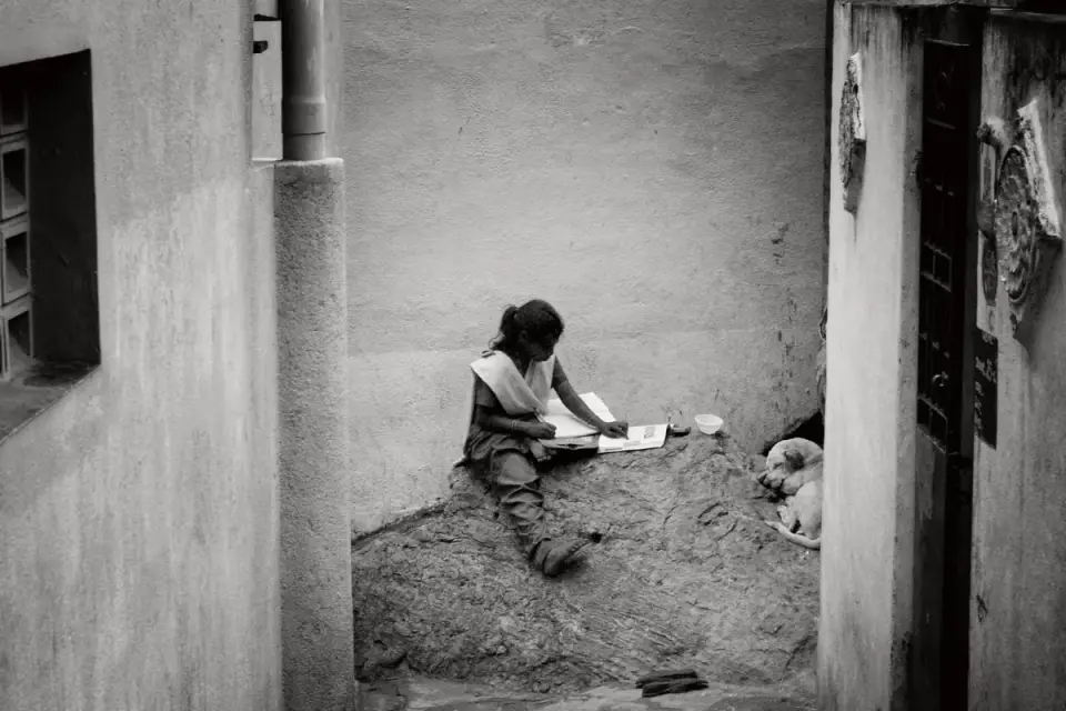 A veterinarian reviewing a dog&#x27;s chart with a small dog resting nearby