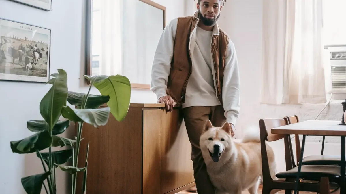 Owner closing a hallway gate while a dog watches from the other side