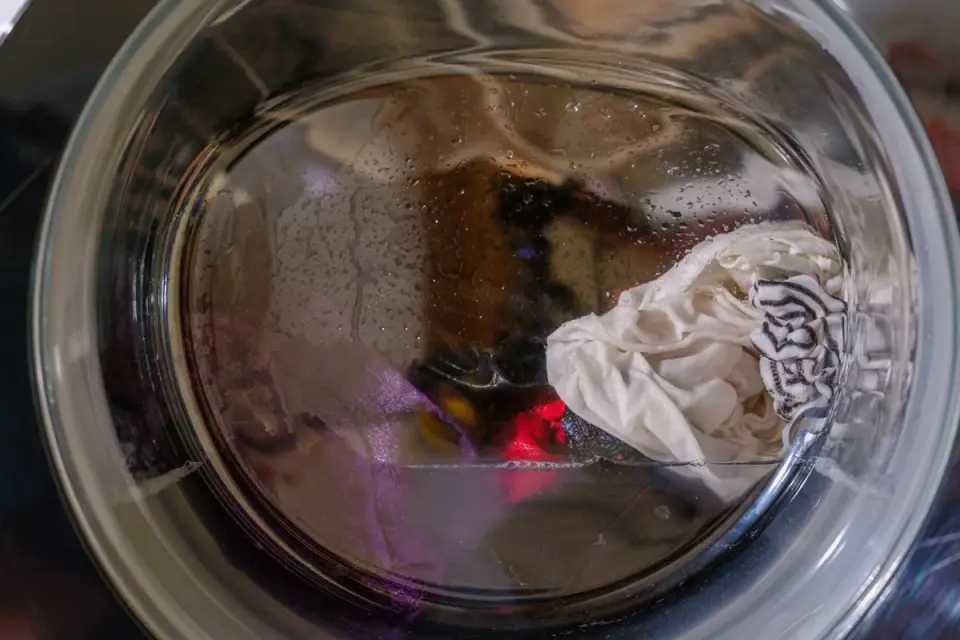 Plush dog toys packed into a mesh laundry bag before a washing machine cycle